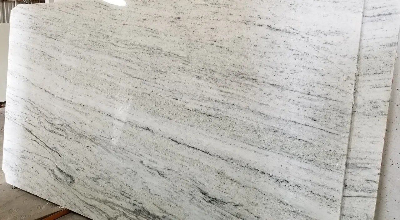 A white granite slab is sitting on top of a wooden table.