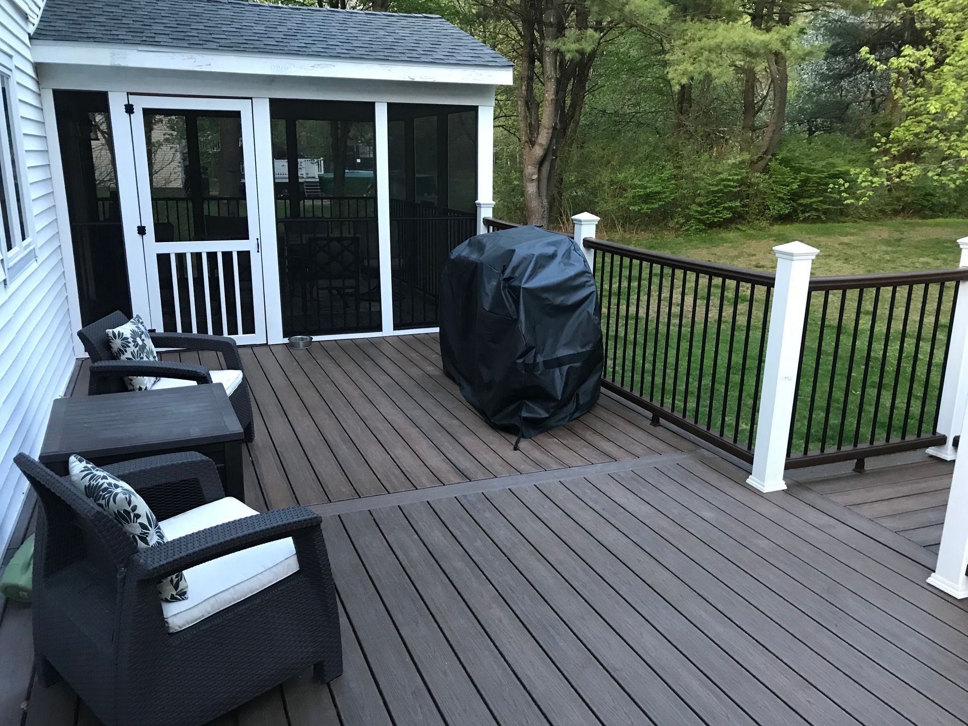 Deck with outdoor furniture, screened porch, and grill.