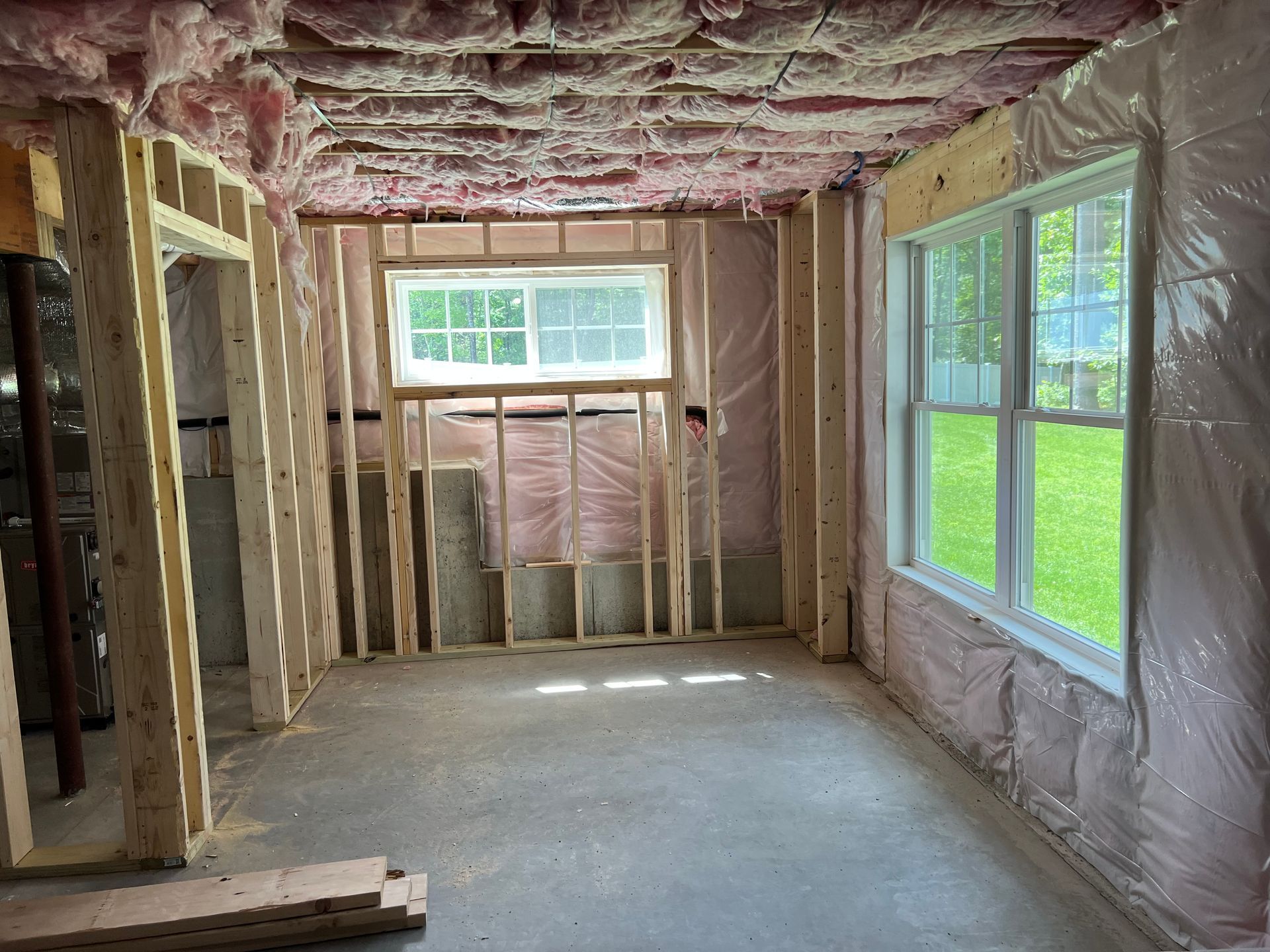 Framed room with insulation and windows, ready for drywall.