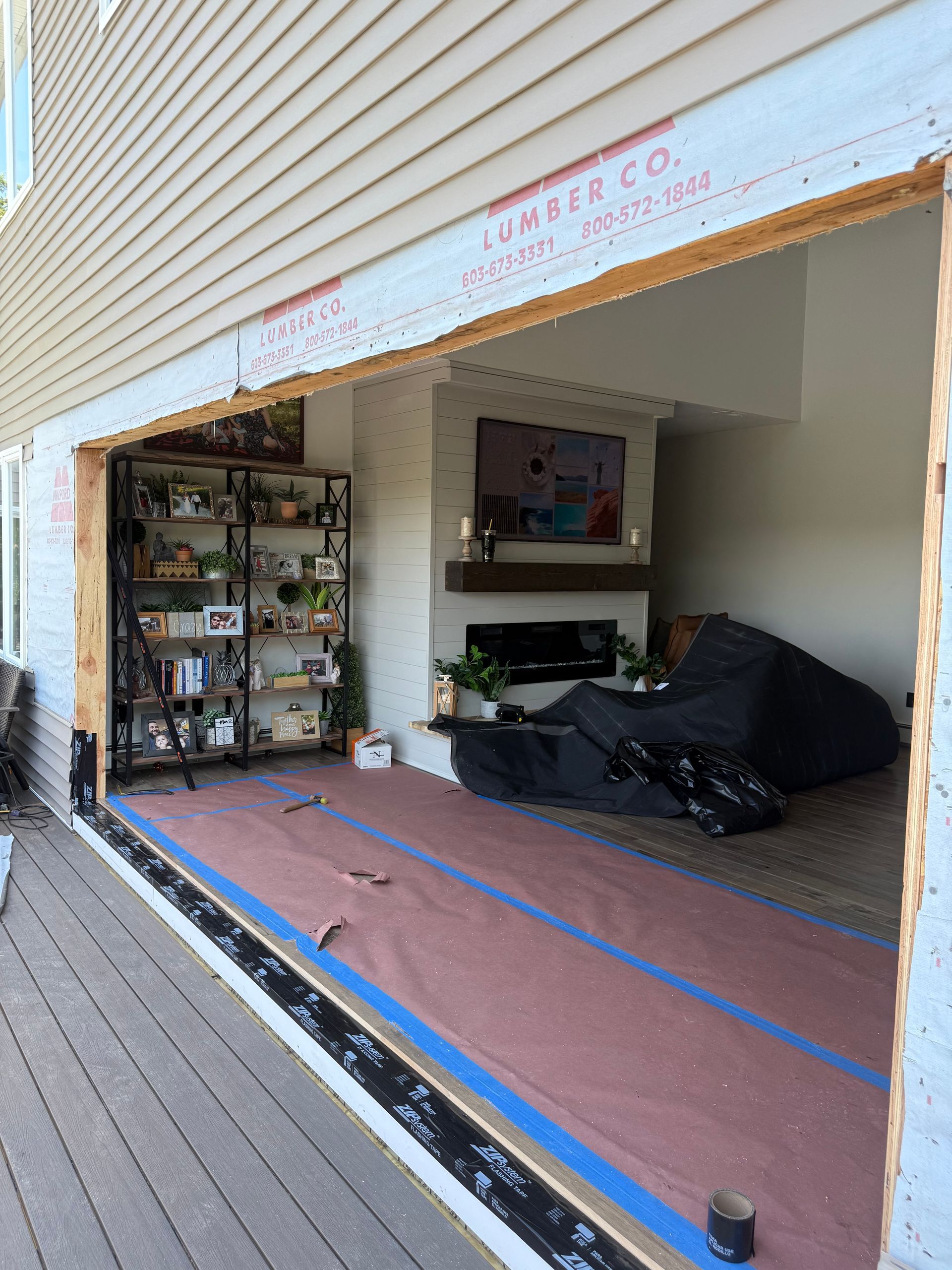 Exterior view of a new sliding door opening, showing interior living space with furniture and decorative items.