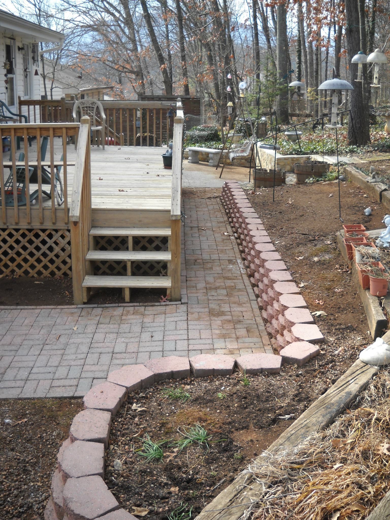 A brick walkway leading to a deck with stairs