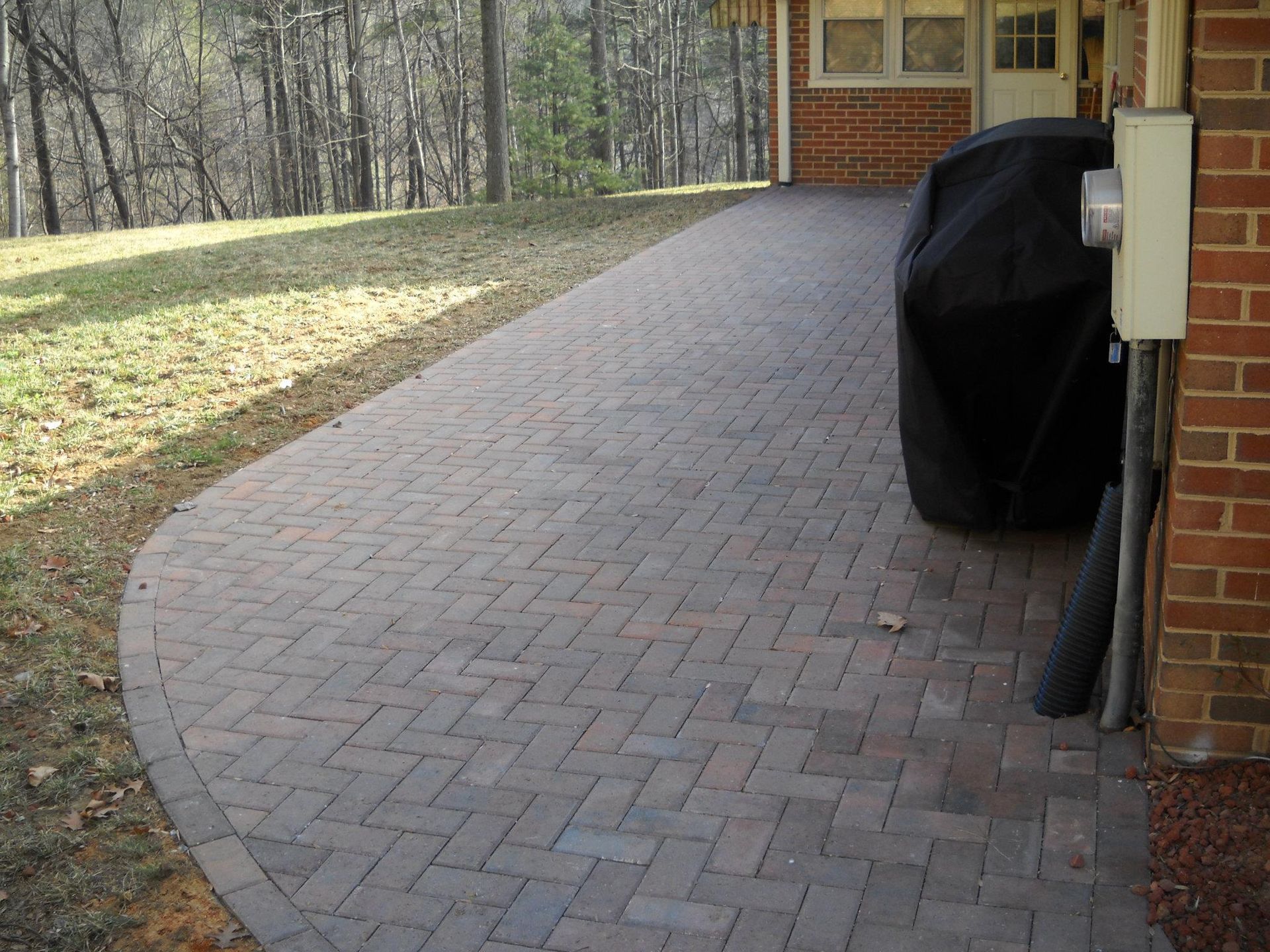 A brick walkway leading to a brick house