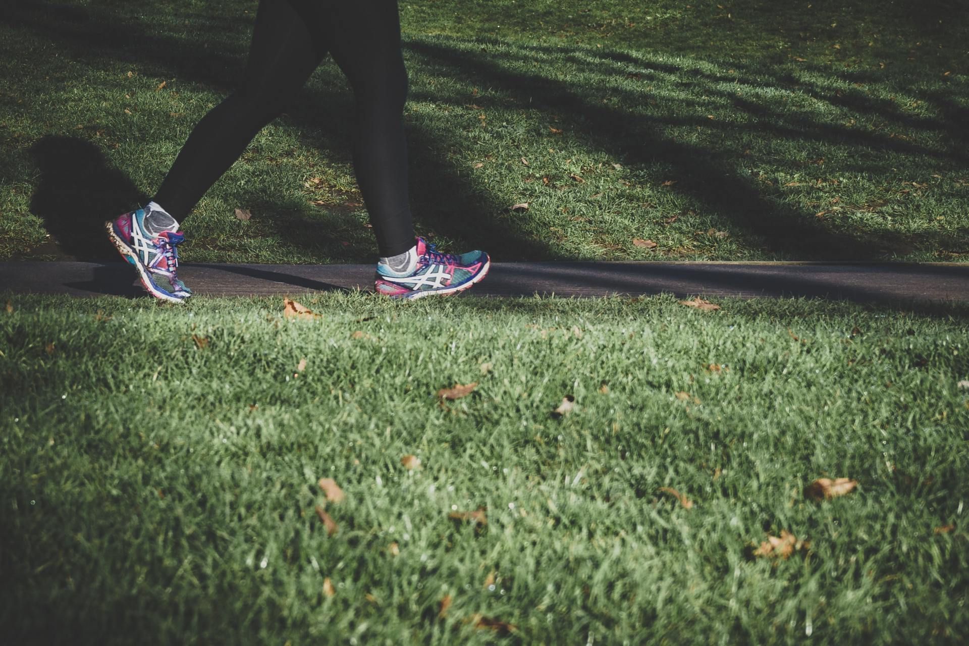 A person is walking down a path in a park.