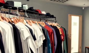 A row of clothes hanging on a rack in a store.