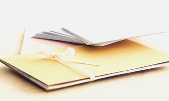 A yellow book with a white ribbon tied around it
