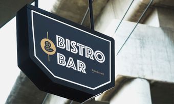 A bistro bar sign hangs from the ceiling of a building