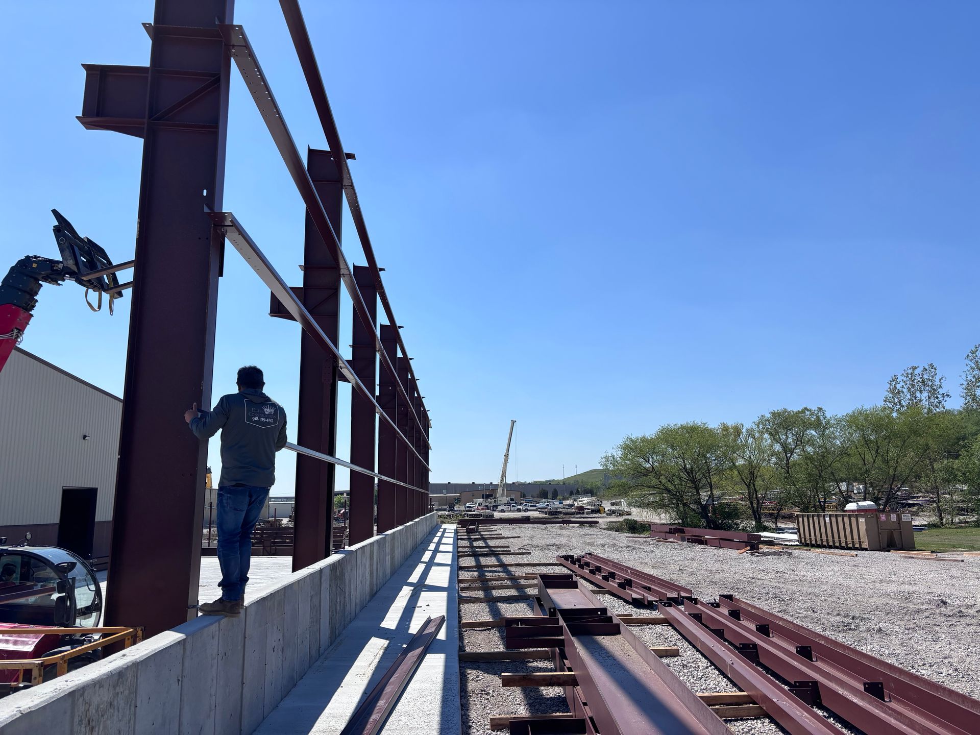 Workers installing steel beams at a construction site on a sunny day