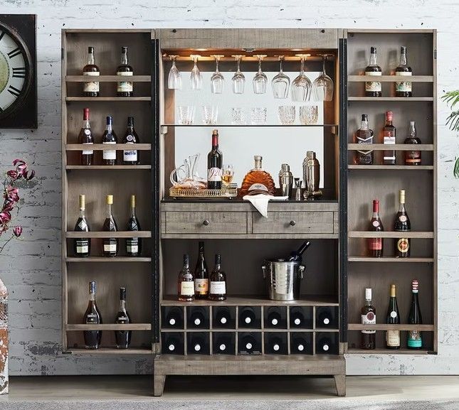 Wooden bar cabinet with wine bottles, glasses, and a mirrored back.