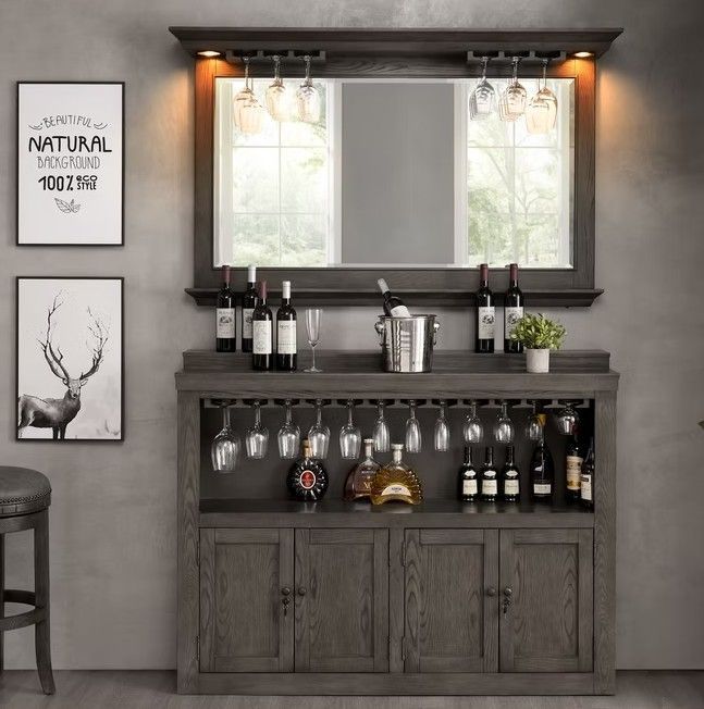 Wooden home bar with wine bottles, glasses, and a mirror.