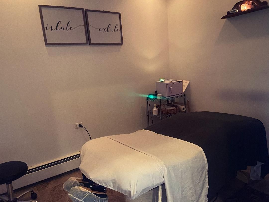 Massage room with two massage tables, a stool, and 