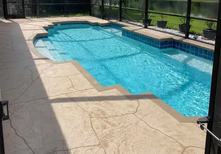 A large swimming pool with a screened in area in the backyard.