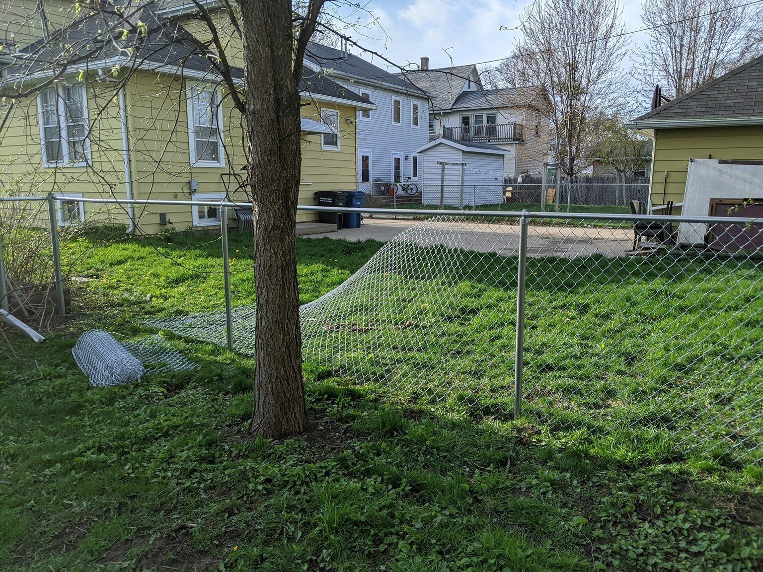 There is a chain link fence in the backyard of a house.