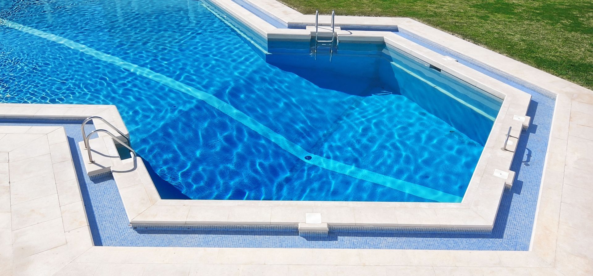 Blue swimming pool with clear water and white tiled edges, viewed from above