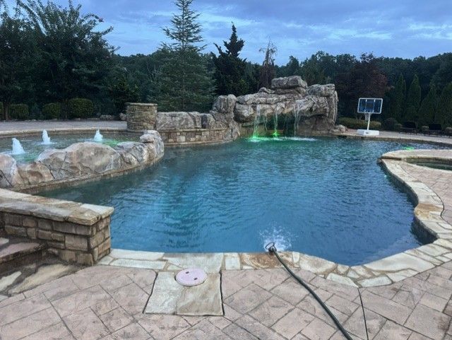 Outdoor swimming pool with blue water, metal ladder, and lounge chairs on the deck