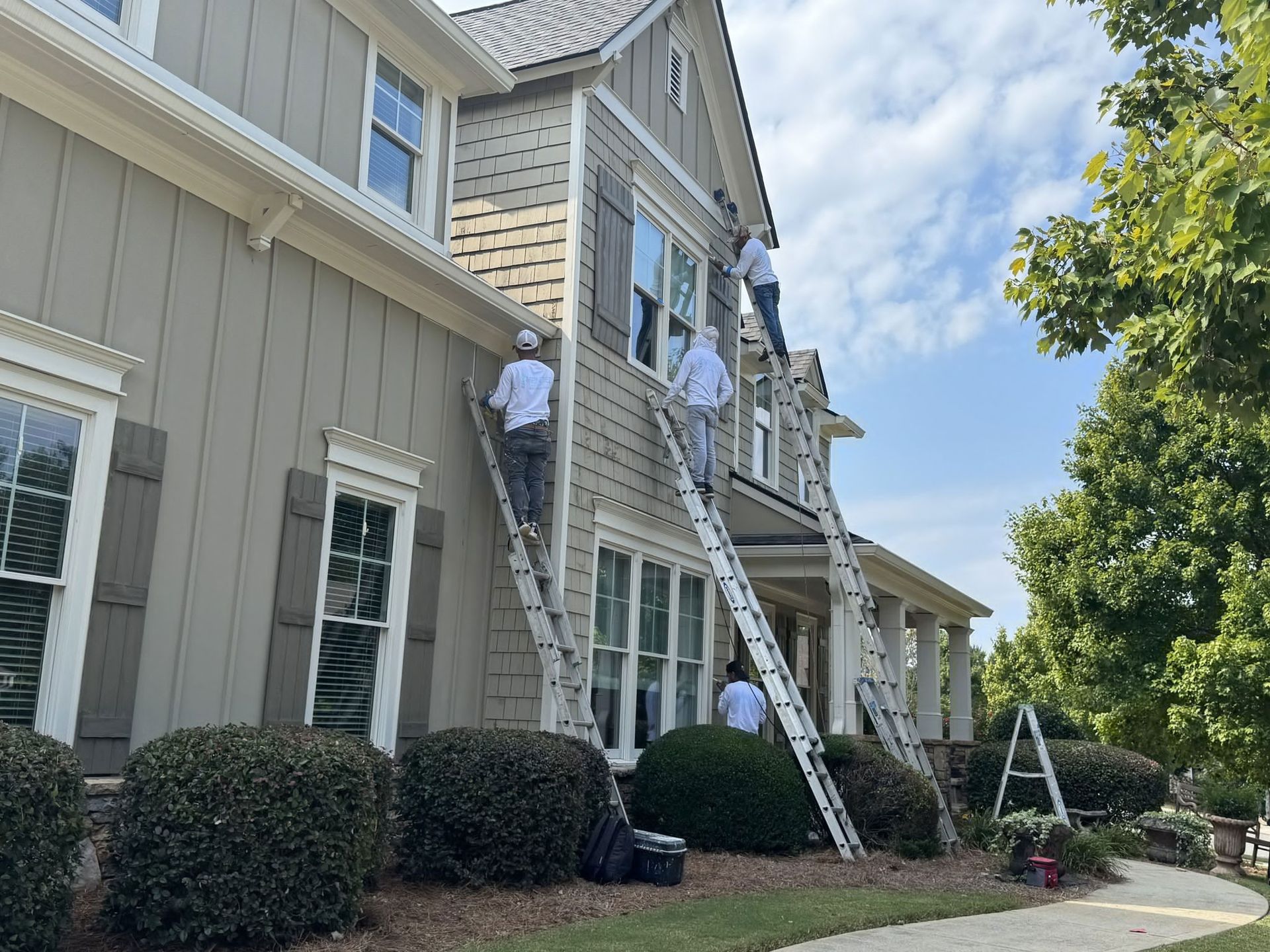 A group of people are painting the side of a house.