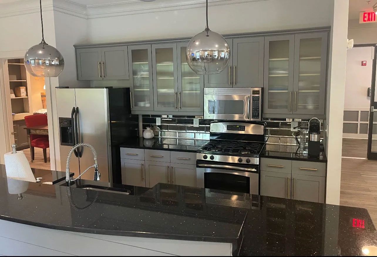 A kitchen with stainless steel appliances and gray cabinets