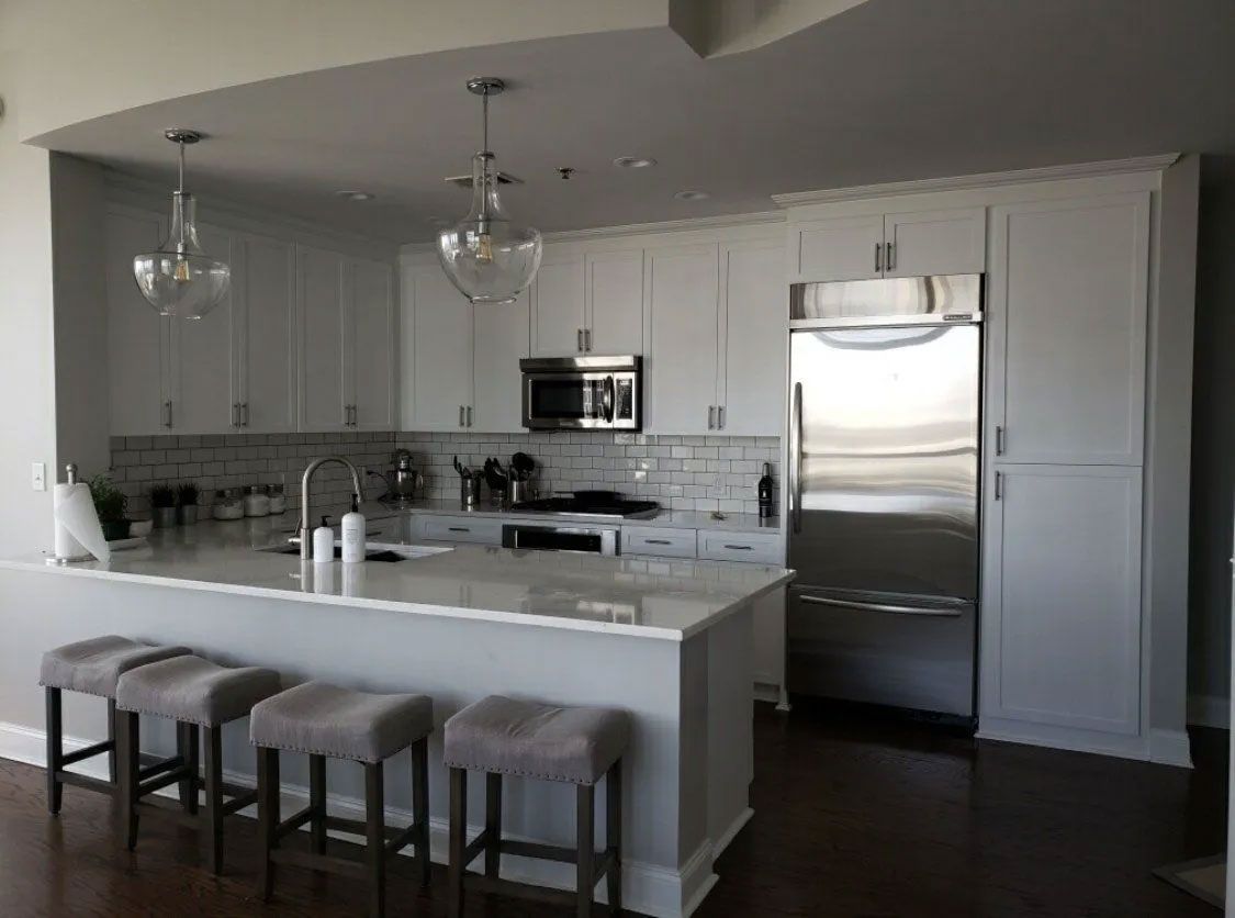 A kitchen with white cabinets and stainless steel appliances