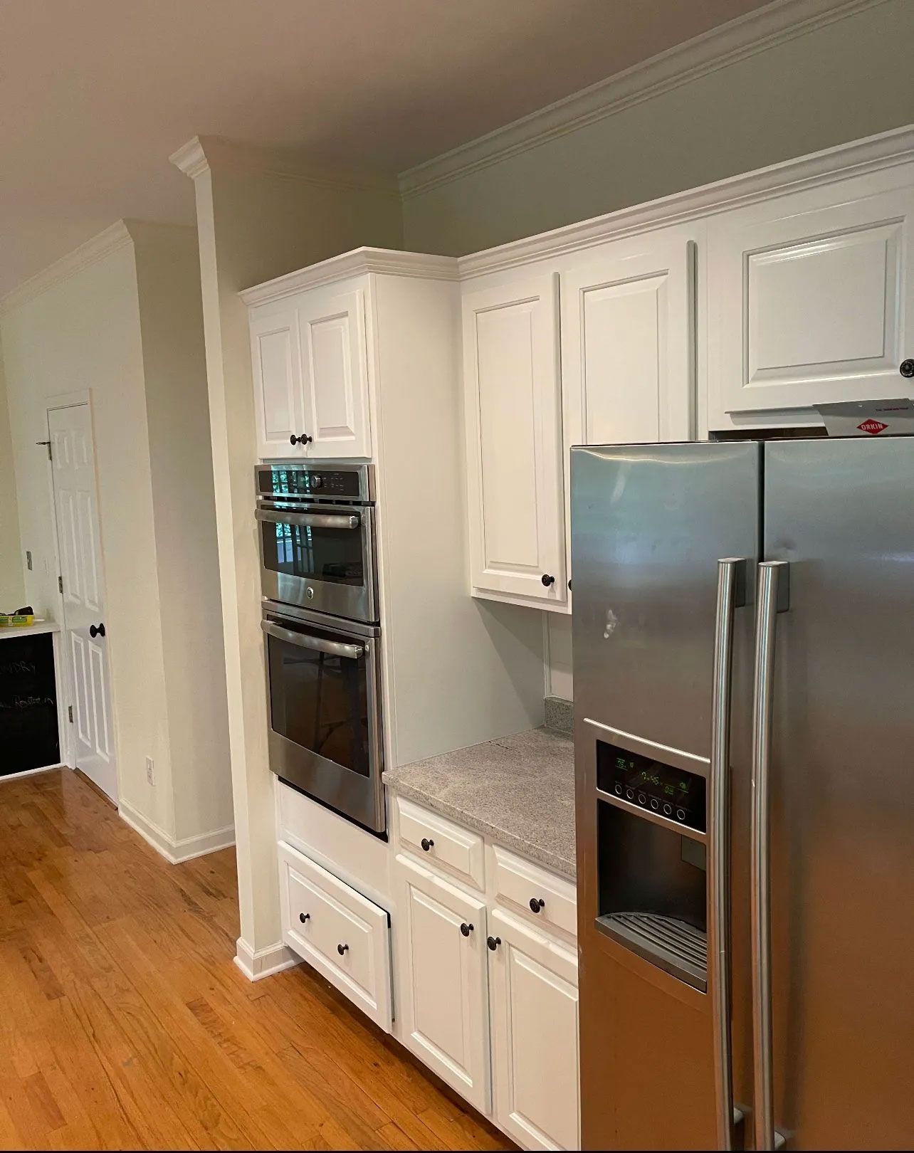 A kitchen with stainless steel appliances and white cabinets.