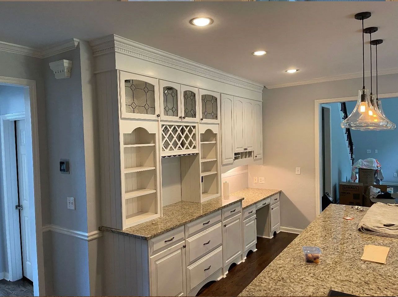 A kitchen with white cabinets and granite counter tops.