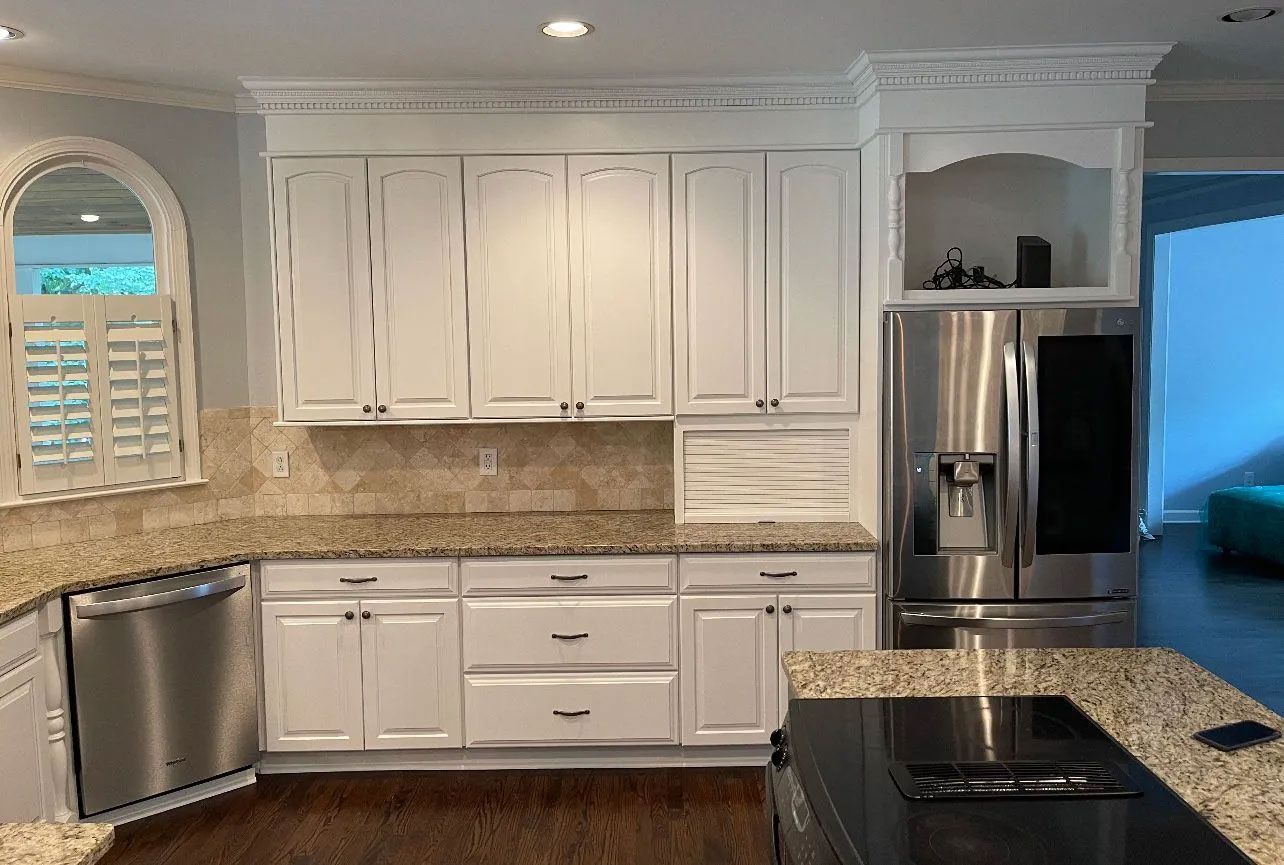 A kitchen with white cabinets and stainless steel appliances.