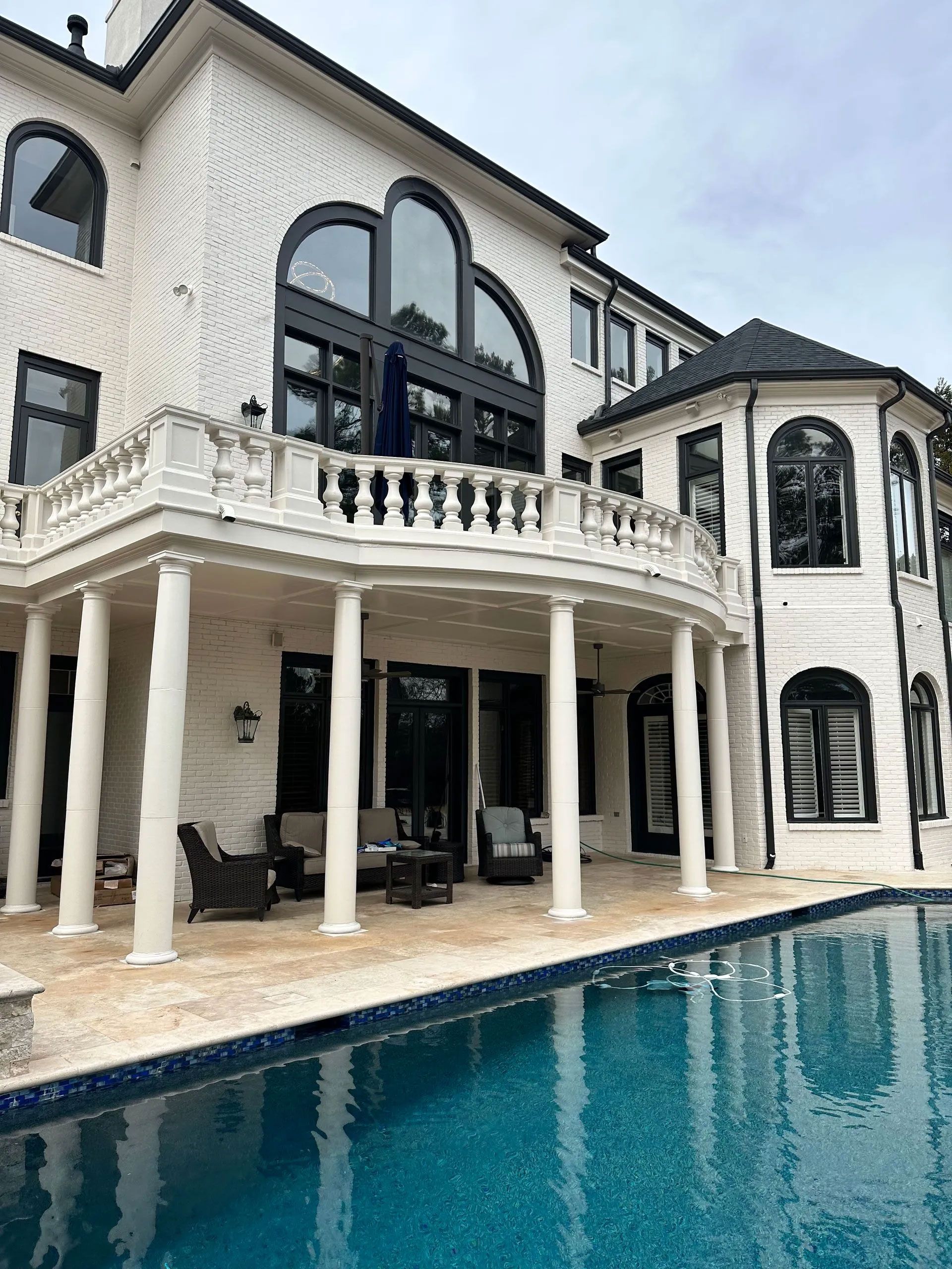 A large white house with a swimming pool in front of it.