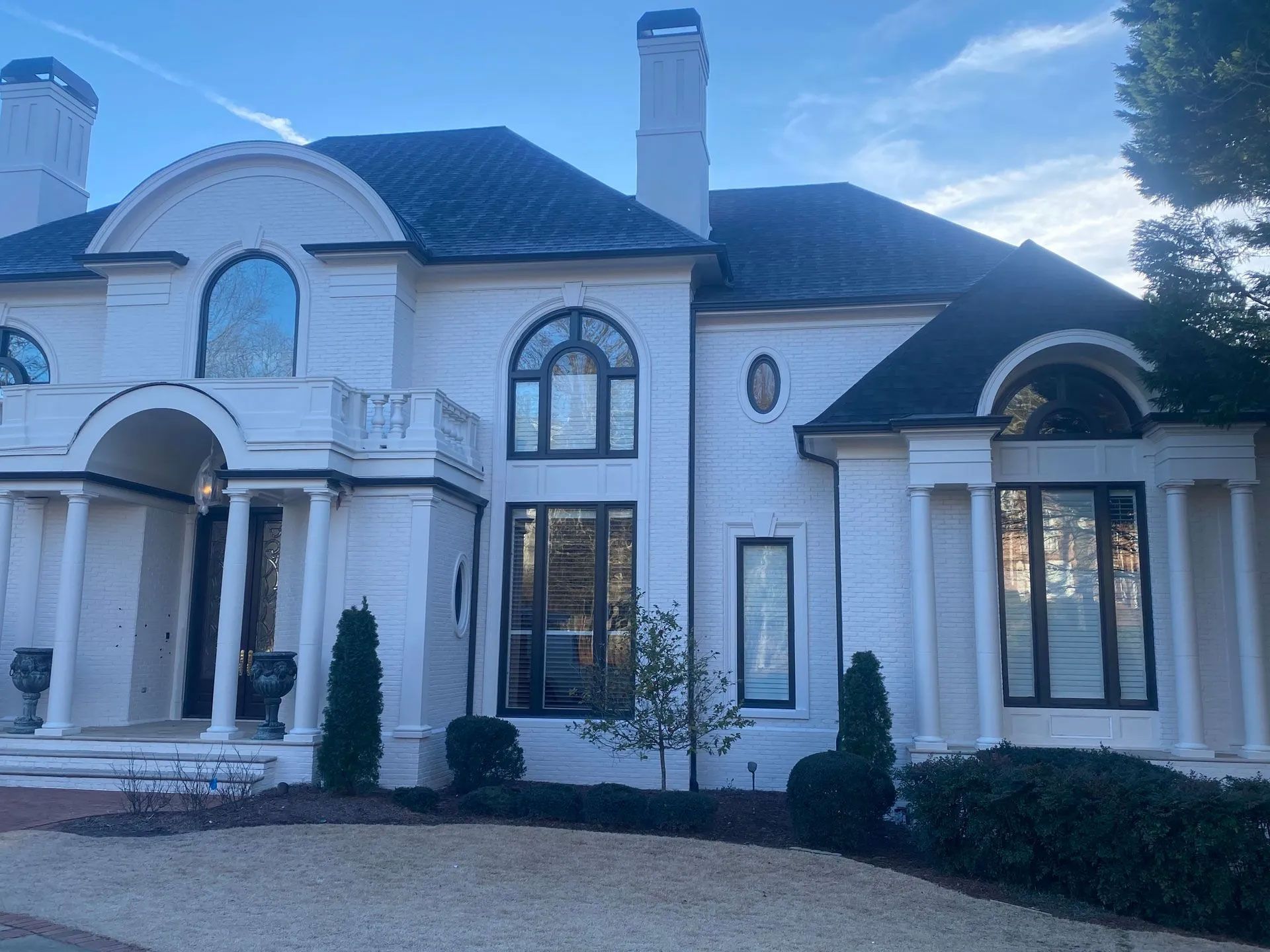 A large white house with a black roof and a lot of windows