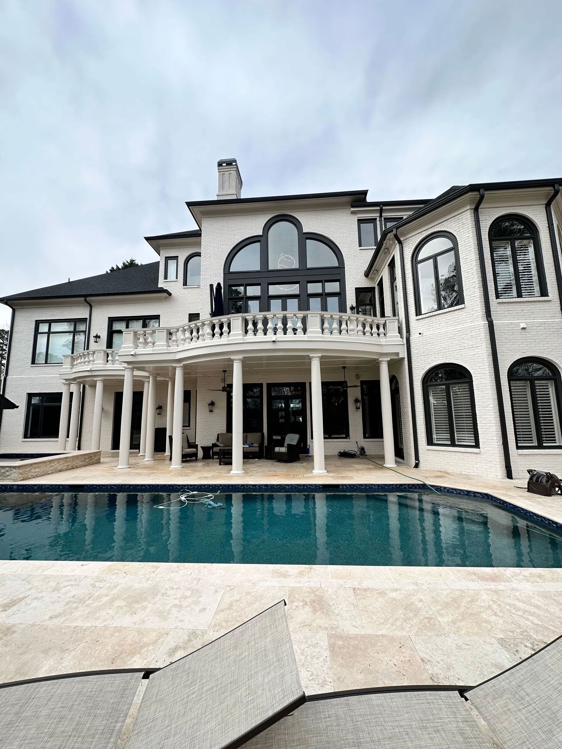 A large white house with a swimming pool in front of it.