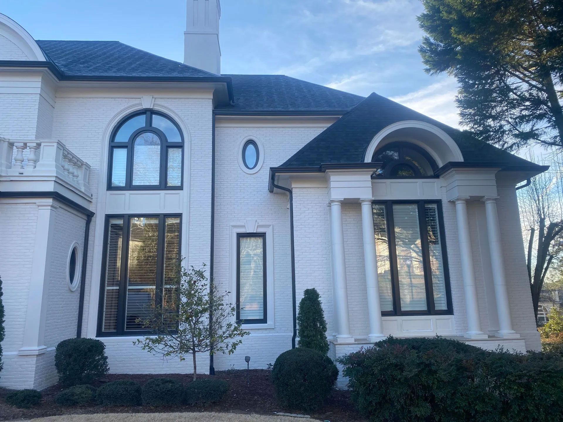 A large white house with black windows and a black roof.