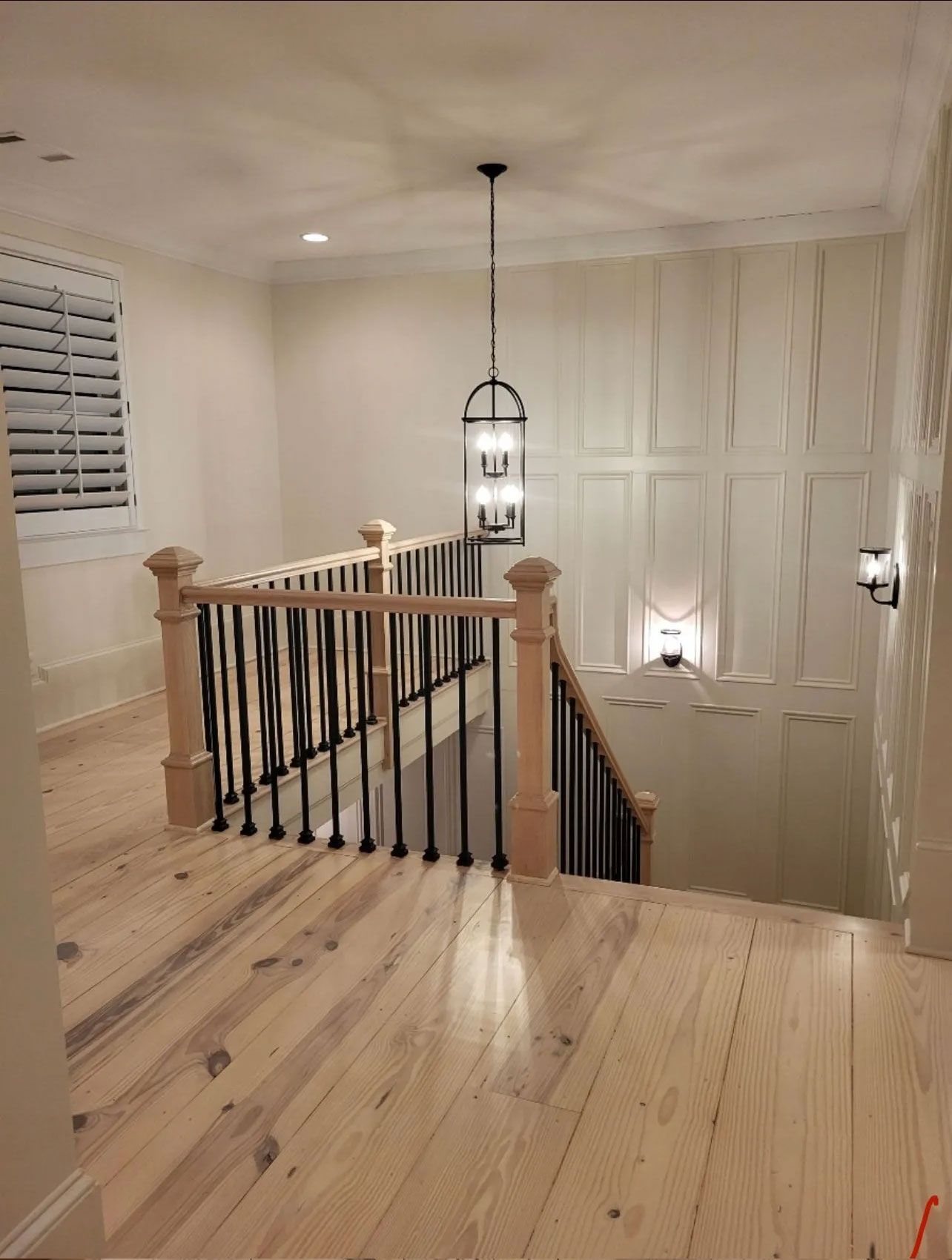 A wooden staircase with a black railing in a house.