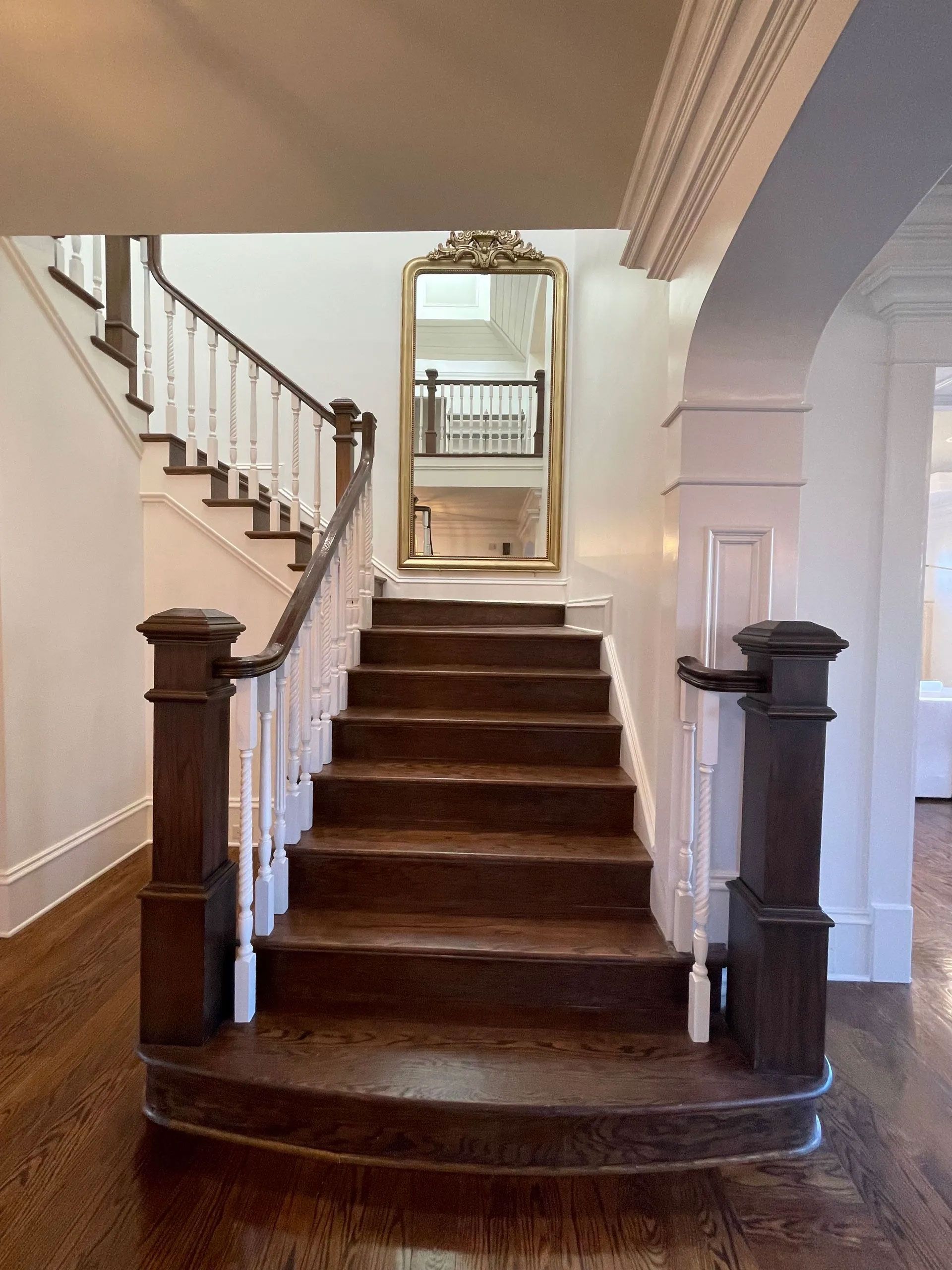 A staircase in a house with a mirror on the wall