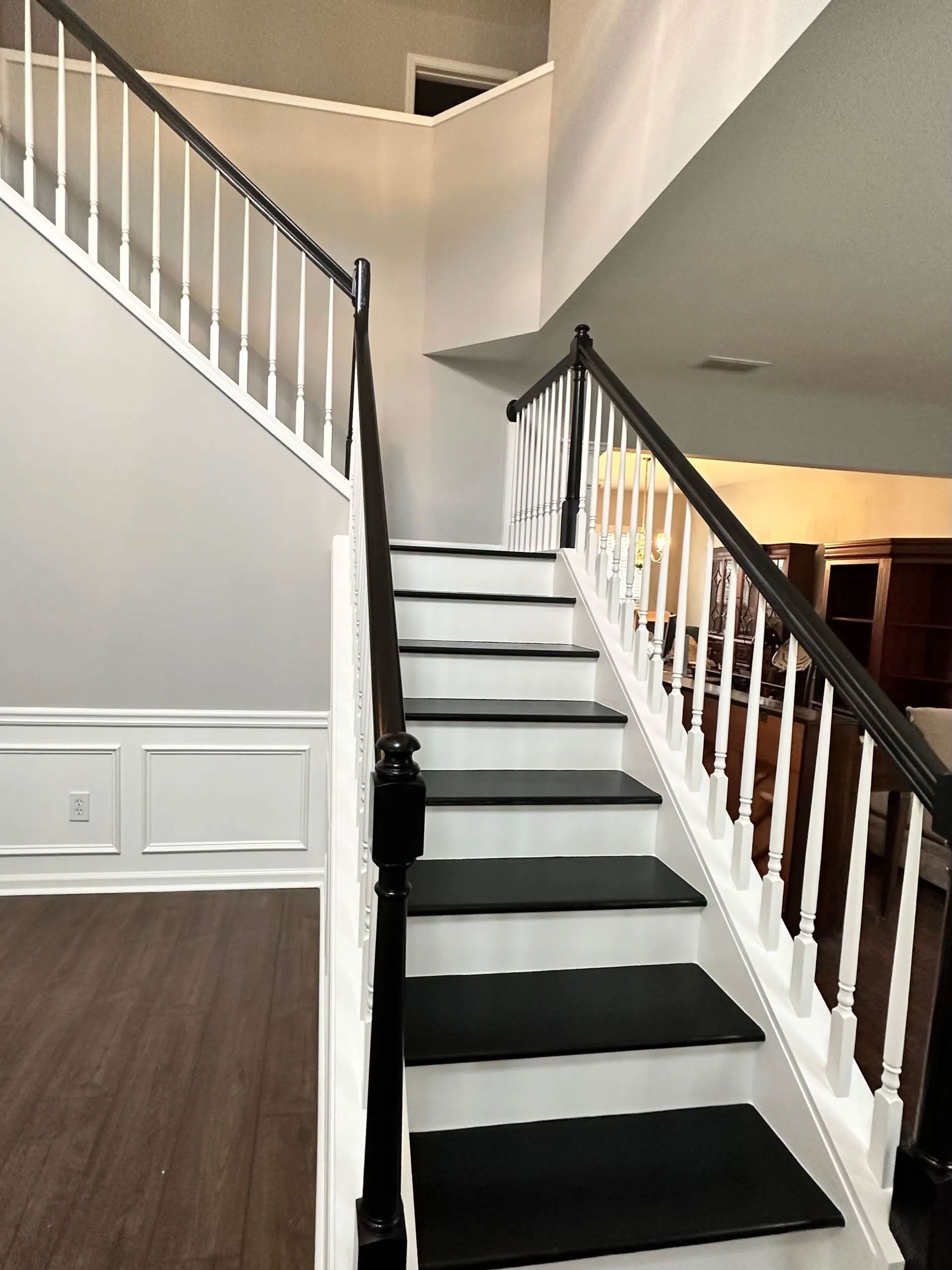 A staircase with black steps and white railing in a house