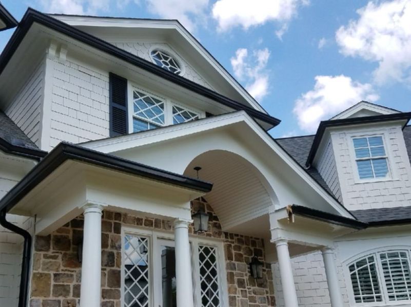 A large white house with a stone facade and a porch