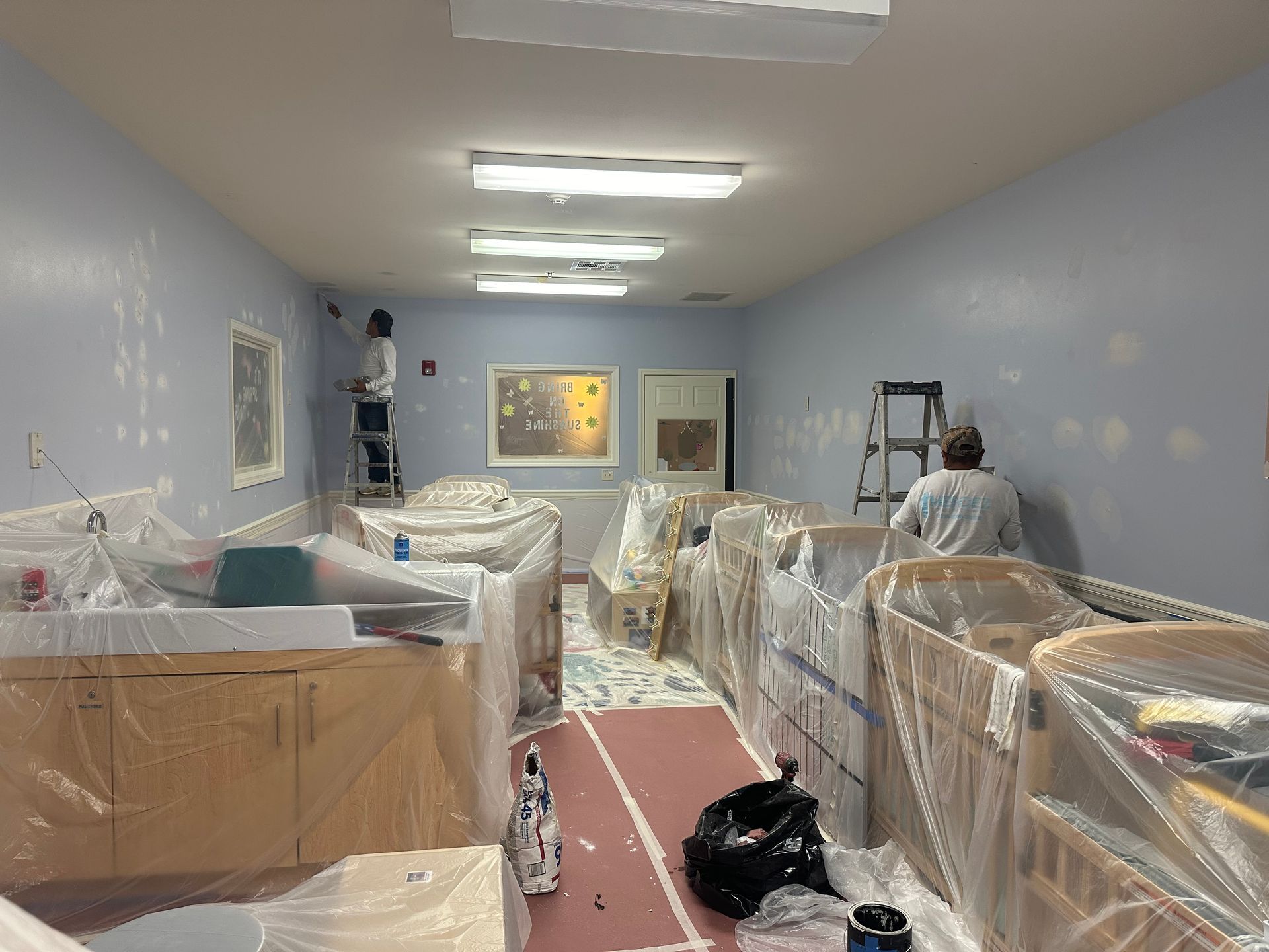 A man is painting the walls of a room.