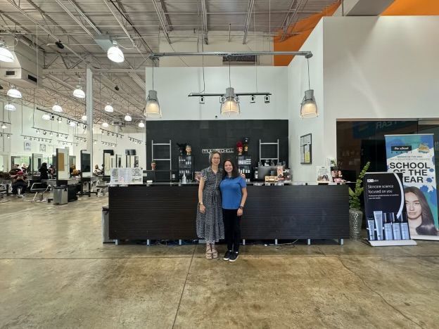 Two women standing in front of a counter in a salon
