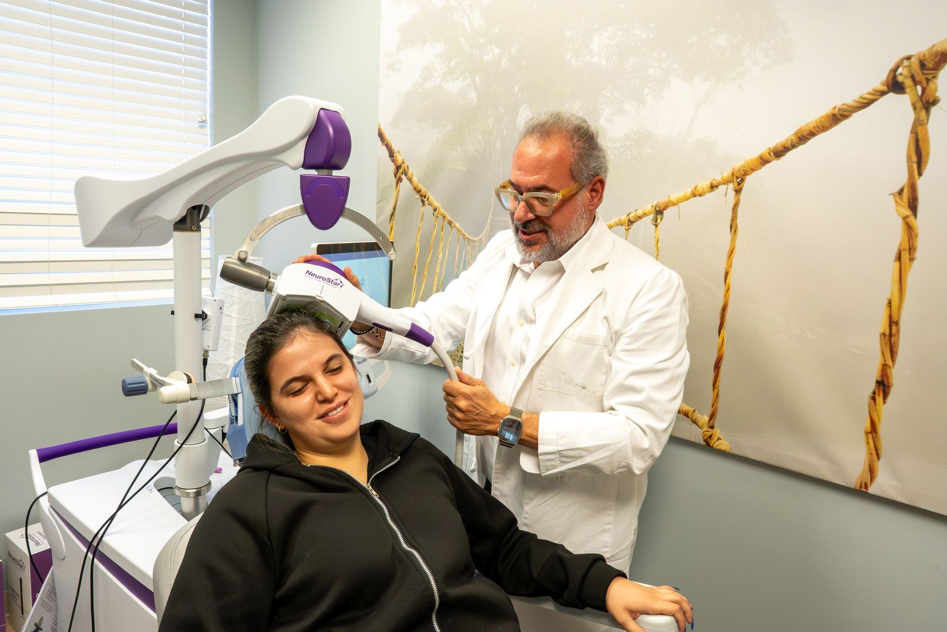 Dentist using a handheld device on a smiling patient in a dental clinic