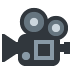 A dark gray icon of a vintage-style motion picture camera.