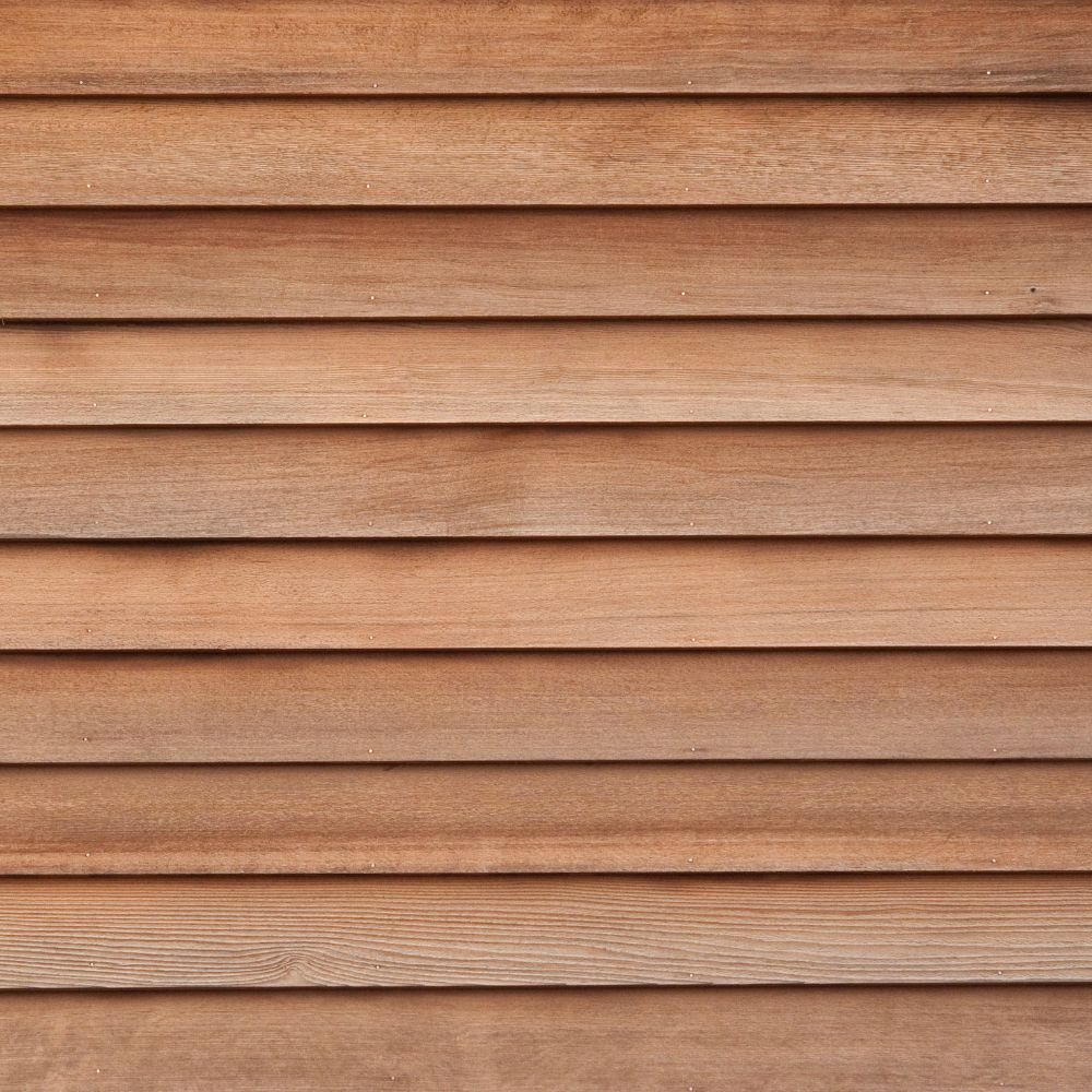 A close-up view of horizontal wooden planks forming a textured, light-brown wood panel wall.