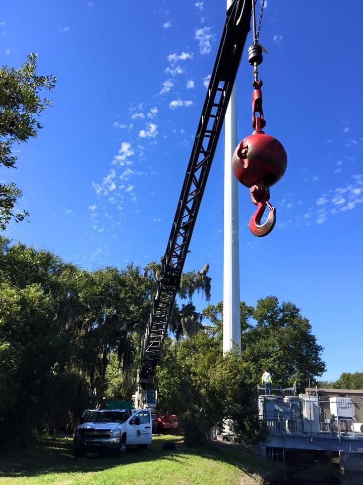A crane is lifting a red ball in the air