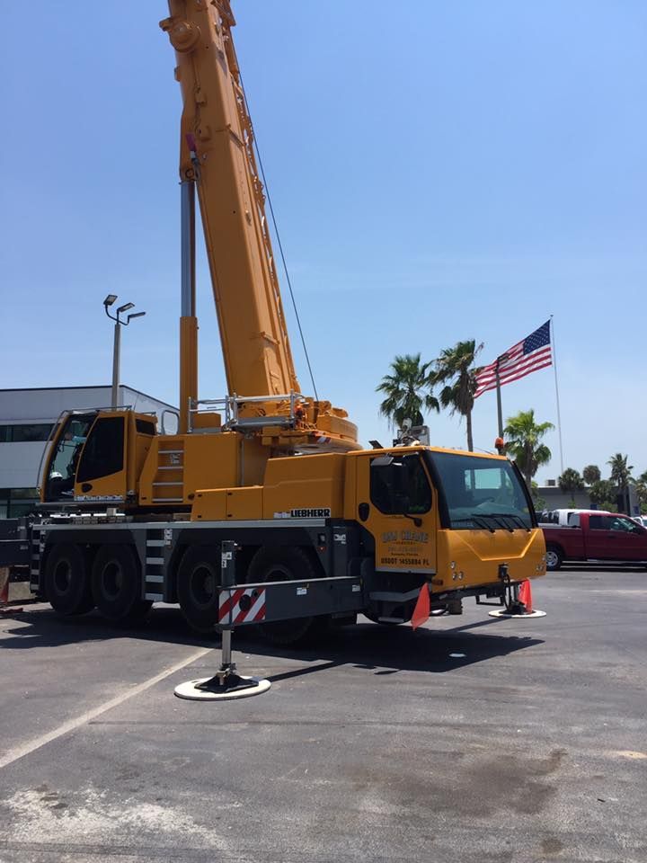 A large yellow crane is parked in a parking lot