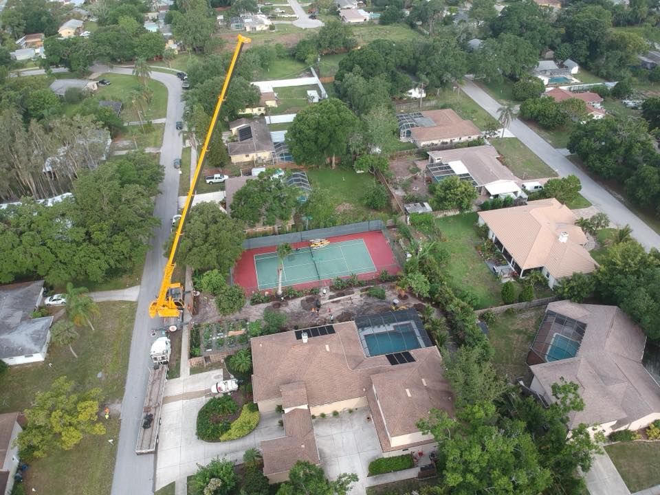 An aerial view of a residential area with houses and a tennis court