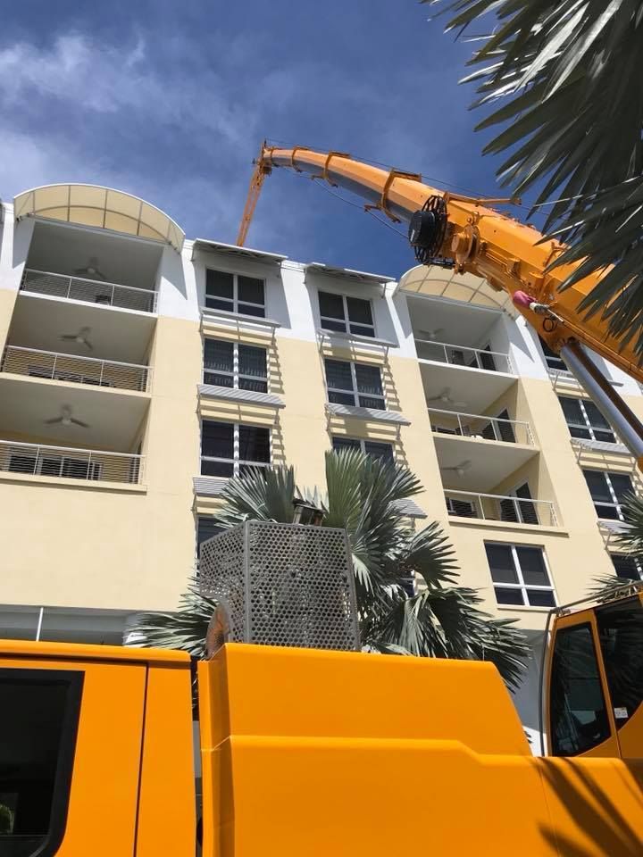 A yellow truck is parked in front of a large building