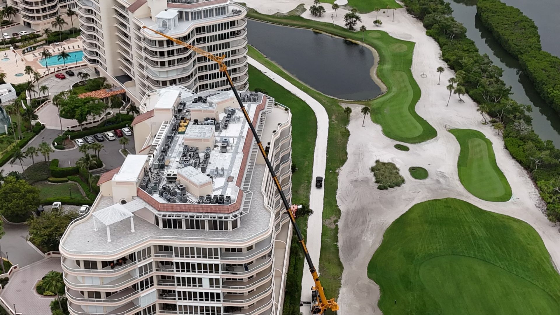 An aerial view of a building under construction next to a golf course.