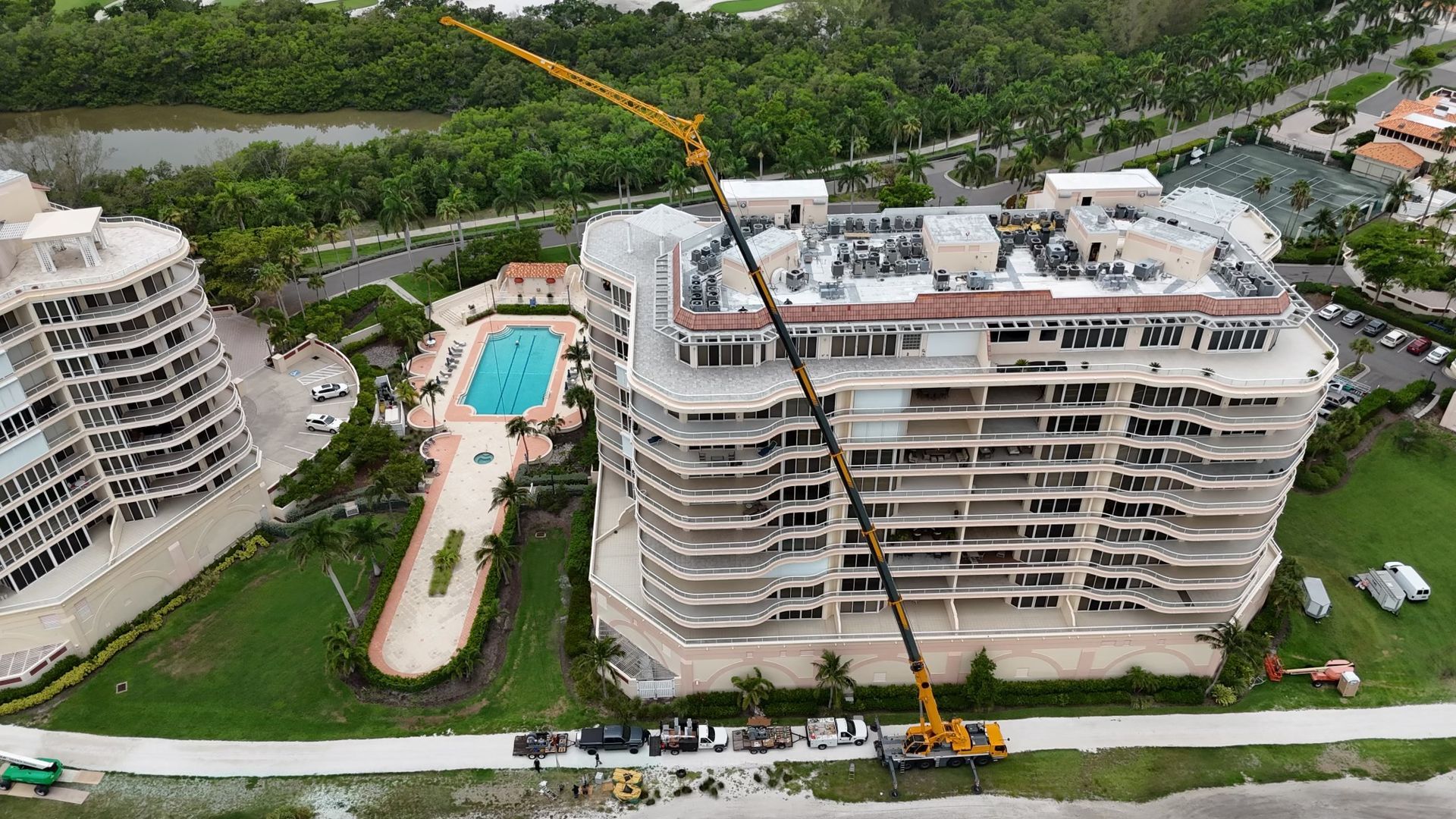 An aerial view of a large building under construction with a crane on top of it.