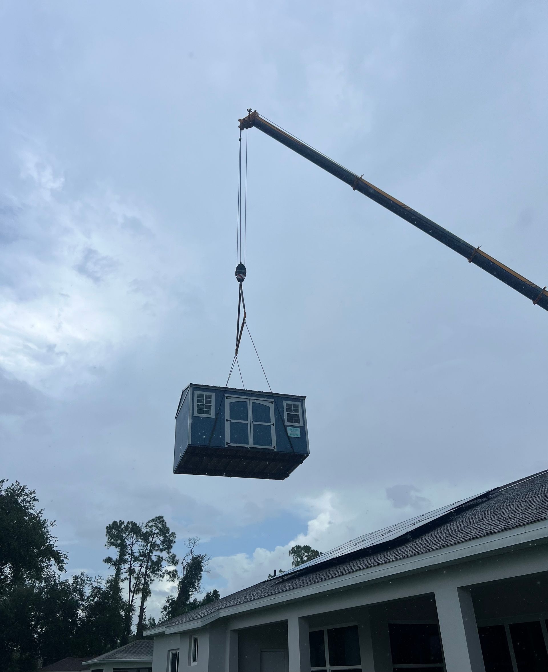 A crane is lifting a basketball scoreboard into the air
