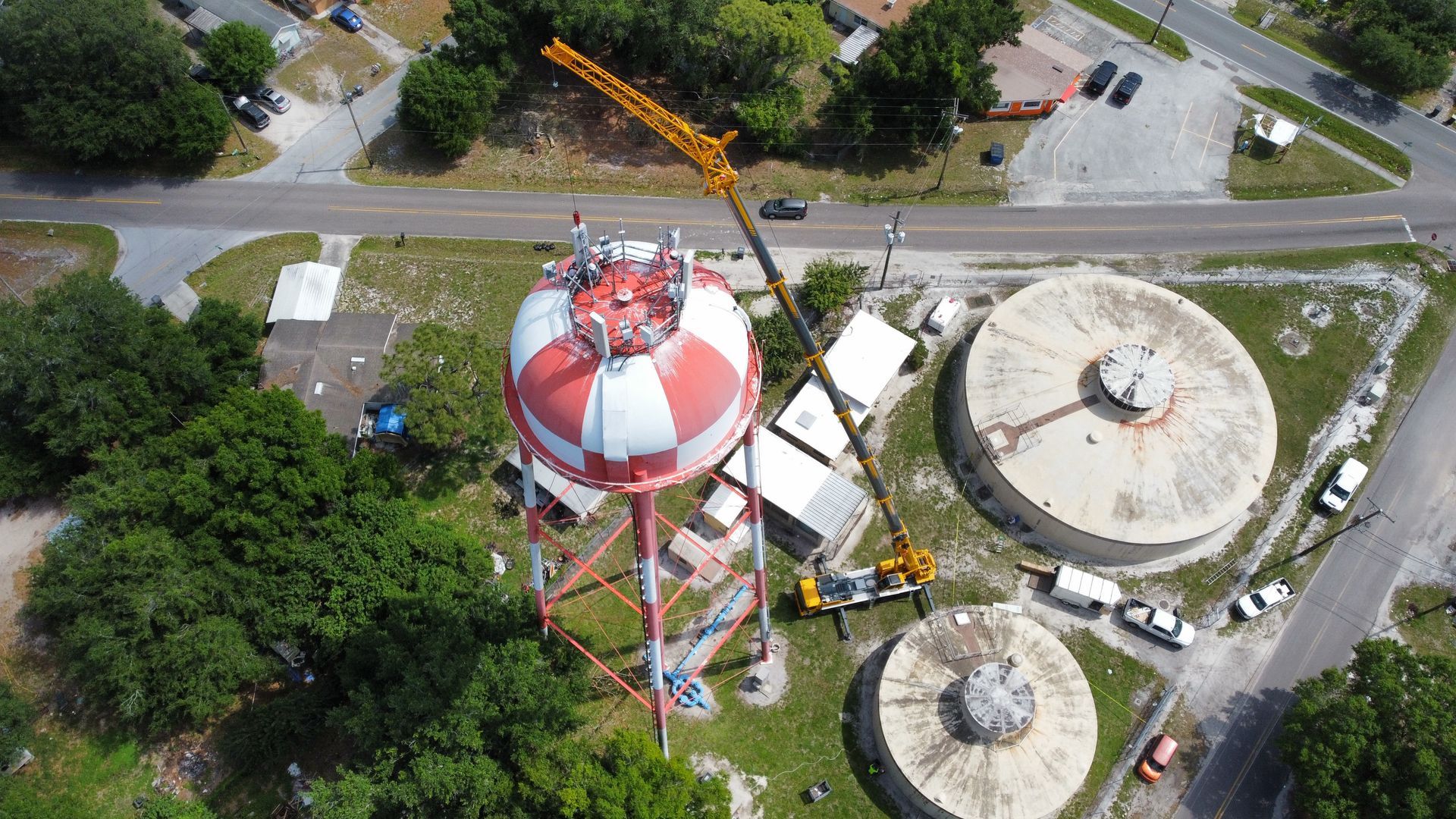 An aerial view of a water tower being built with a crane.