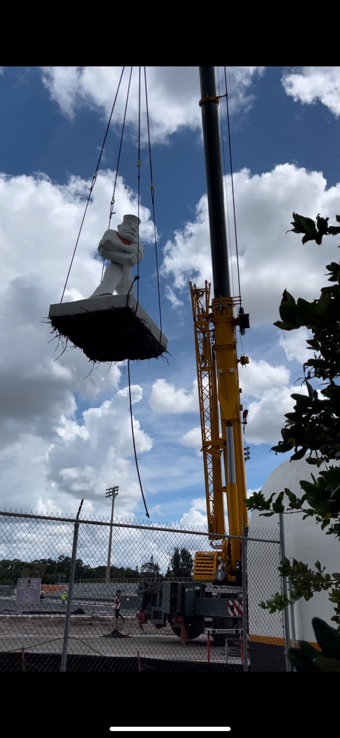 A large statue is being lifted by a crane.