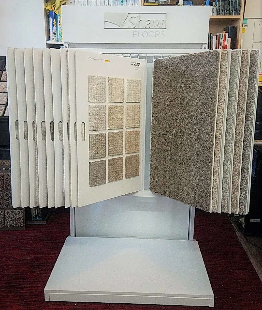 A floor display of carpet samples, featuring hanging boards with texture and color swatches for flooring selection.