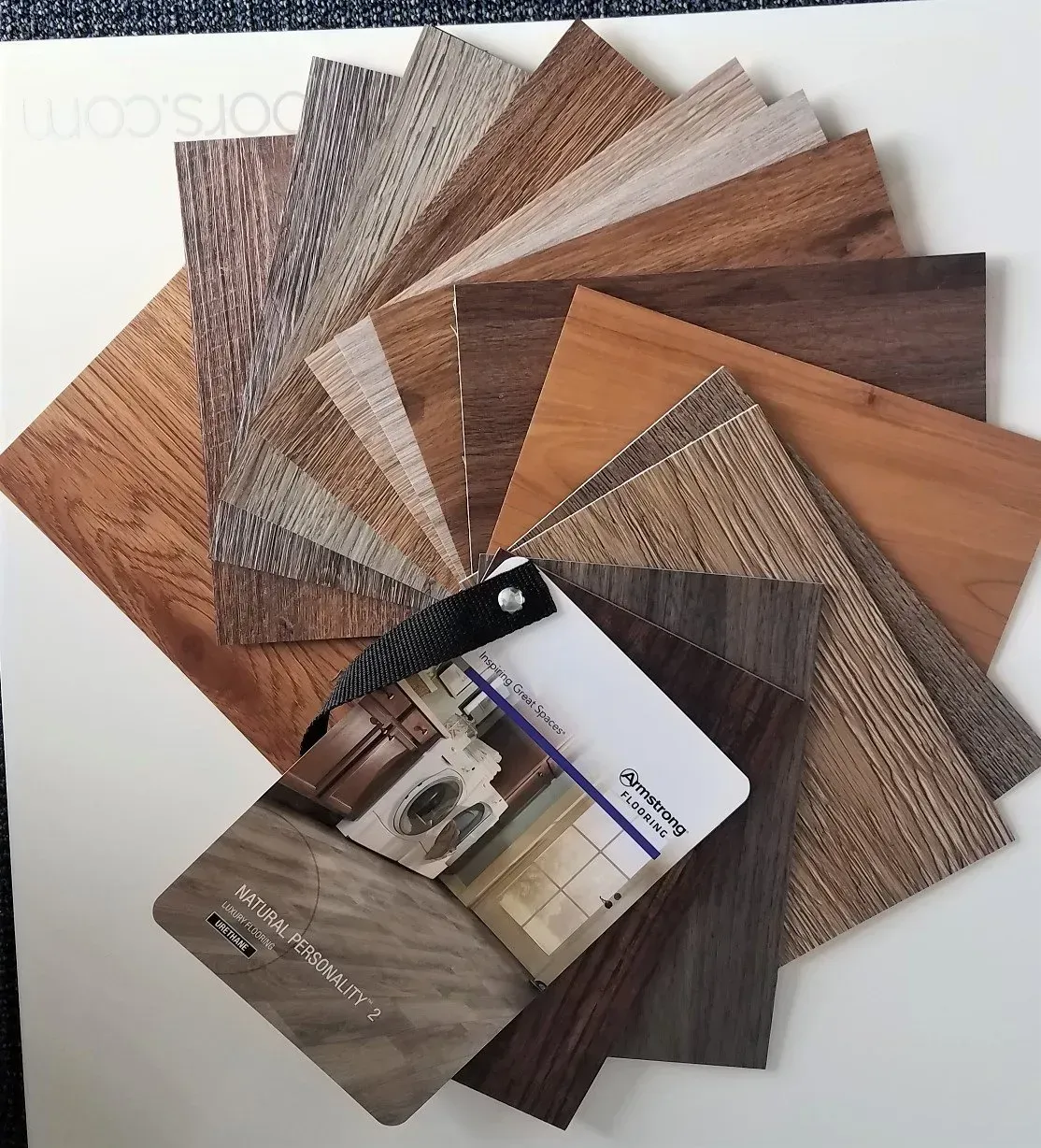 A fan deck of wood and textured cabinet finish samples arranged on a white surface.