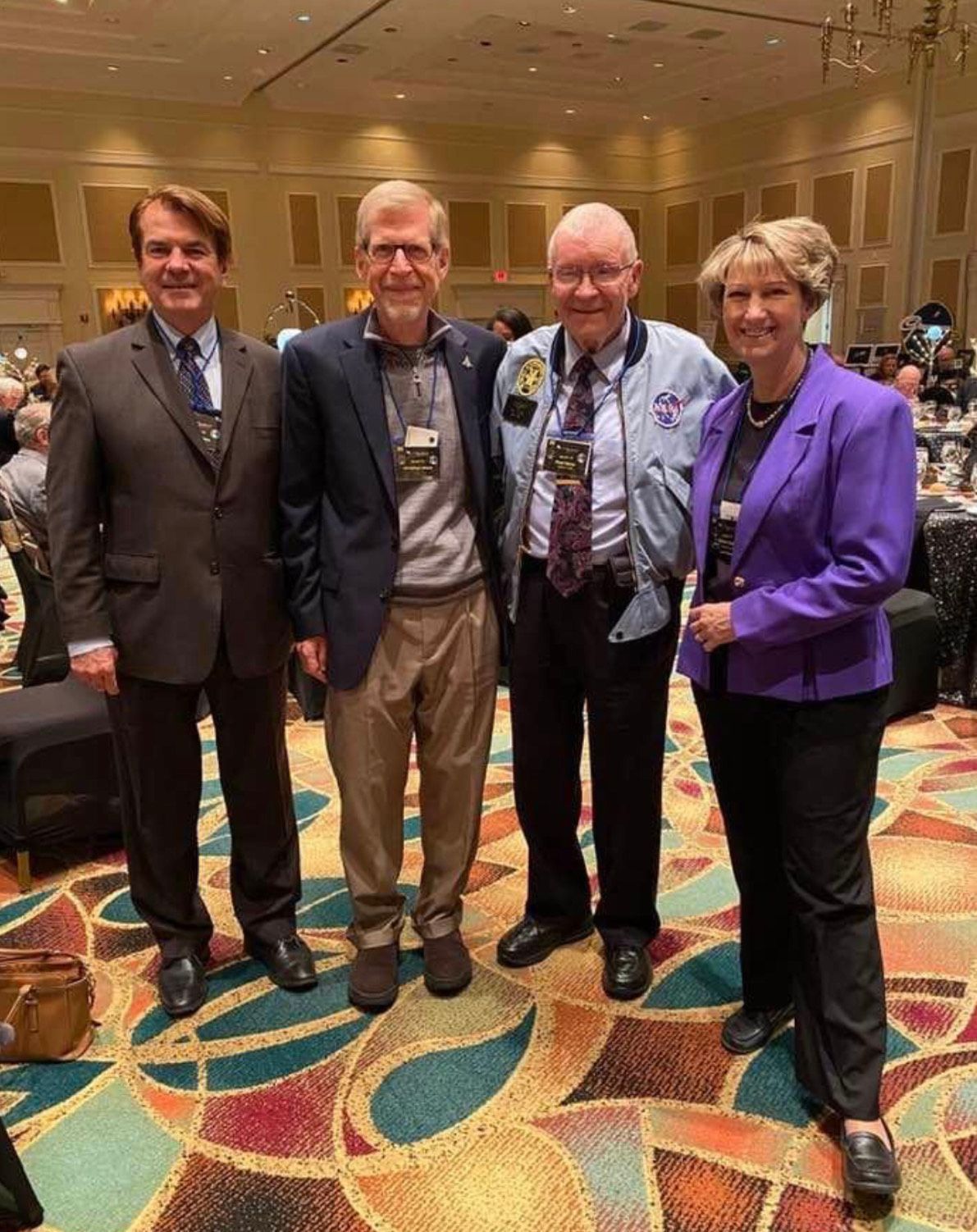 Four people posing together at a conference