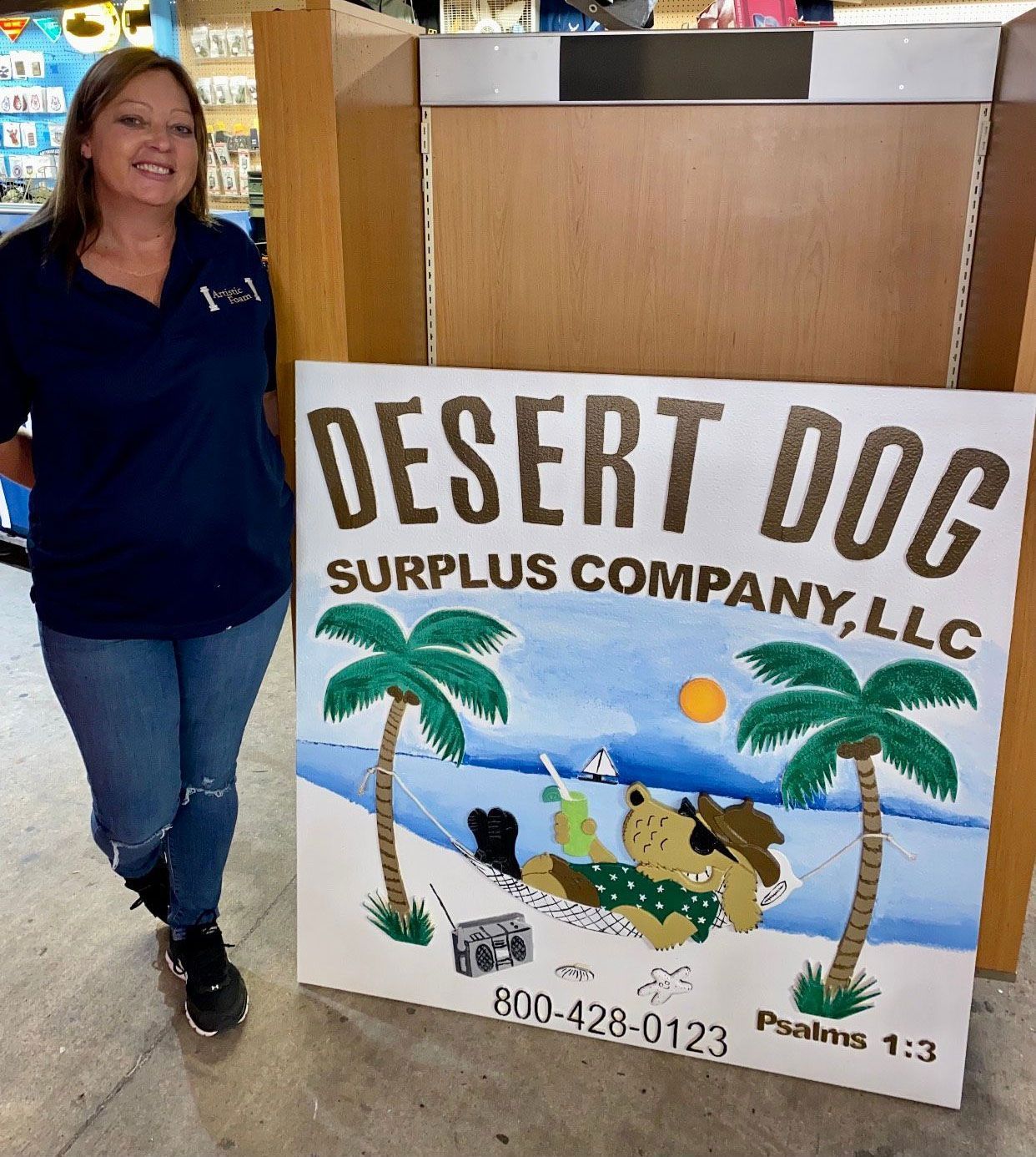 Woman stands beside Desert Dog Surplus Company, LLC sign